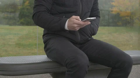 Close-up of a man using smart phone at a bus stop Stock Footage 68679291