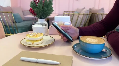 Close up of man using smart phone sitting in cafe in daytime Stock Footage 258596507