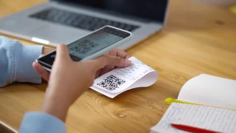 Close up of man using smartphone to scan qr code to pay bill Foto stock