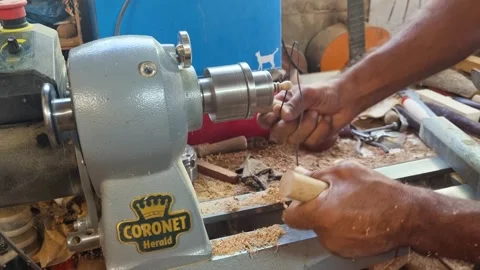 Close-up of man using a wire to burn and blacken a wooden toys grooves Stock Footage 292794747