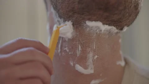 Close up of a man using a yellow disposable razor and shaving cream to remove Stock-Footage 335152226