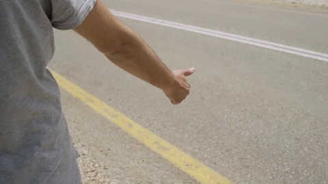 Close Up of a man waiting for a ride on the side of the road Stock Footage 107542192
