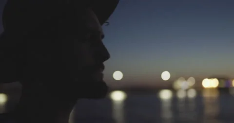 Close up of man walking on pier and playing on guitar after sunset 스톡 동영상 147065495