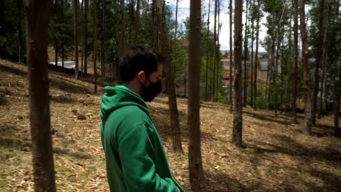 Close-up of a man walking in a pine forest in El Pinar, Huaras in the daytime Stock Footage 164560238