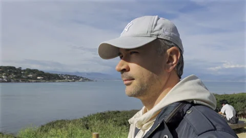Close up of a man walking on a sandy footpath bordered by wooden posts connected Stock Footage 308782083
