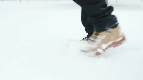 Close up of man walking through several inches of snow during a storm in tan and Vidéo 234347392