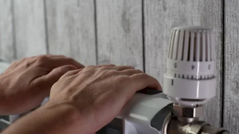 Close-up man warming hands with heating radiator at home Stock Footage 288011480