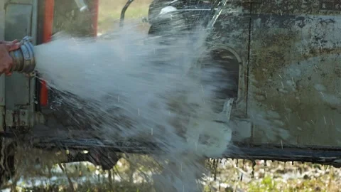 A close-up of a man washing a dirty SUV with a powerful jet of water Stock Footage 344875837