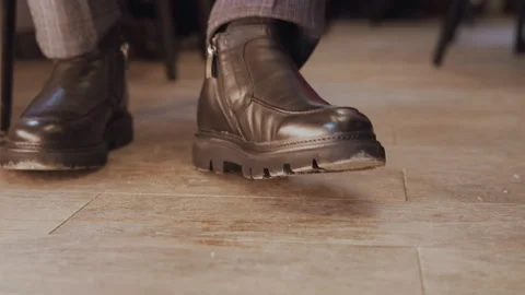 Close up of man wearing black leather boots with thick soles and plaid trousers Stock Footage 344875344