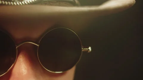 A close-up of a man wearing dark glasses and a cowboy hat, looking at the camera Video stock 325624969