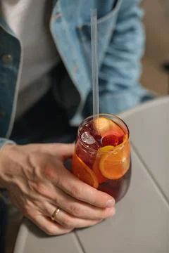 Close-up of man wearing a denim jacket drinking a summer cocktail with orange Stock Photos