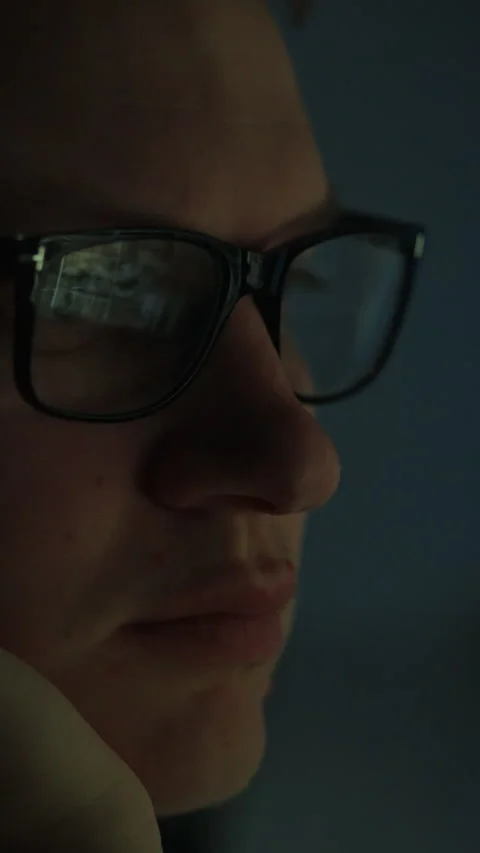 Close-up of a man wearing glasses deep in thought while engaged in a task at Stock Footage 331538768