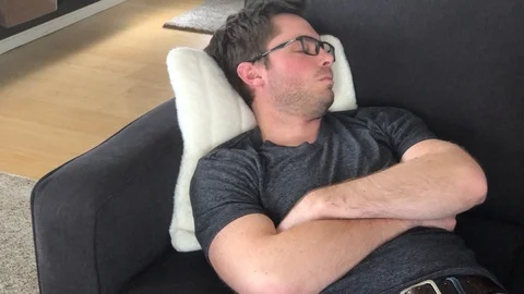 Close up man wearing glasses taking an afternoon nap on the couch Stock Footage
