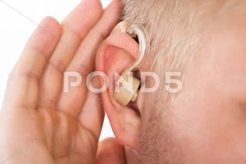 Close-Up Of Man Wearing Hearing Aid In Ear Listening For A Quiet Sound
