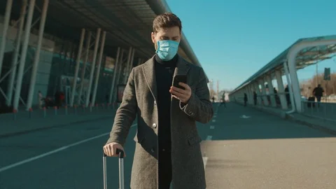 Close up man wearing Protective Face Mask use phone coughs hold suitcase COVID Stock Footage 126619089