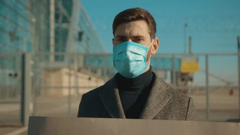 Close up man wearing protective mask on street hold poster from pandemic to Stock Footage 126583204