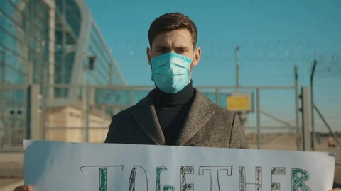 Close up man wearing protective mask on street hold poster Together we stop Stock Footage 126583565