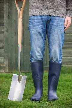 Close Up Of Man Wearing Wellingtons Holding Garden Spade Stock Photos