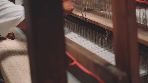 Close up man weaving fabric using shuttles on loom machine 動画素材 90709185