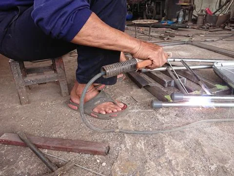 Close up, man welding broken chair at his workshop Stock Photos