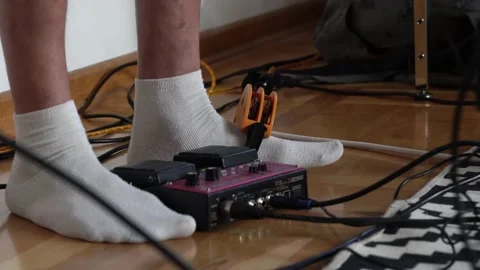Close up A man in white socks beats the rhythm on a tambourine tied to his leg Stock Footage 194682338