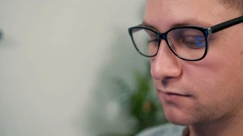 Close to a man who put on his glasses to work on the computer after a break. Stock Footage 148944778