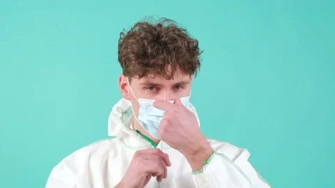 Close up of a man who wears protective suit and medical mask, looking at camera. Stock Footage 151353280