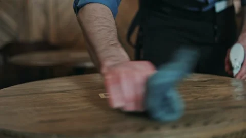 Close up of man wiping table with cloth after finishing working shift at cafe Vidéo 260874073