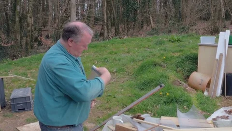 Close-up of man wit paintbrush in hand and painting wooden plank Stock Footage 77938353