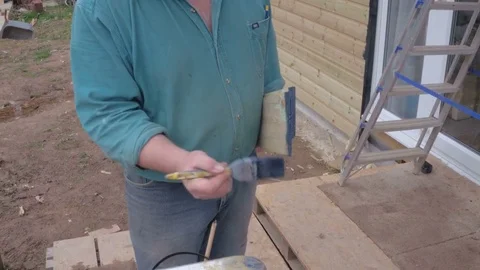 Close-up of man wit paintbrush in hand and painting wooden plank Stock Footage 77940398