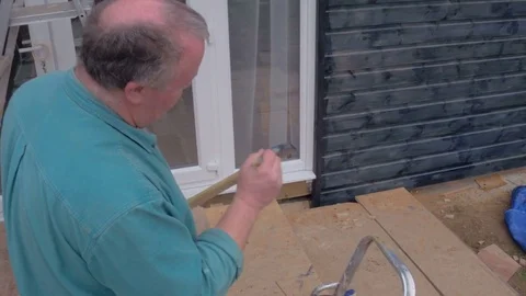 Close-up of man wit paintbrush in hand and painting wooden plank Stock Footage 77943692