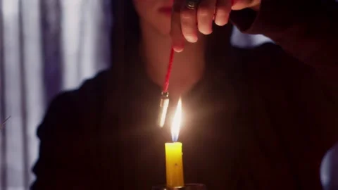 Close up of man wizard rotating a magic pendulum over a candle Stock Footage 143513942