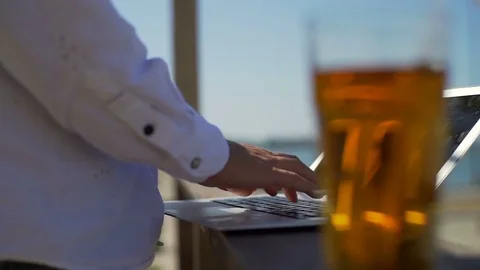 Close up man work on laptop on beach sunny day drink rapid slow motion Stock Footage 80787671