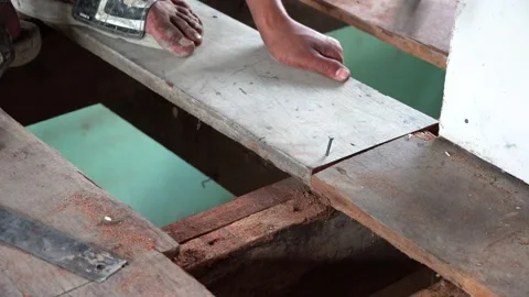 Close up man worker using hammer to nail the wooden planks to fix the house. Stock Footage 169439028