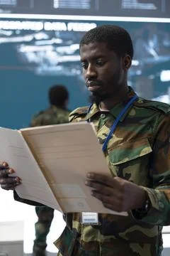 Close up of man working in army operations room, reading briefing files Stock Photos
