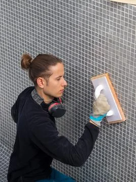 Close up of man working in the construction of a pool using sponge trowel Foto stock