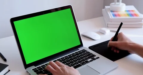 Close up of a man working on a laptop with a green screen chroma key display Stock Footage 126690772