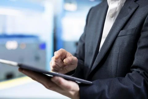 Close up of man working in microchip factory assessing equipment using tablet Foto stock