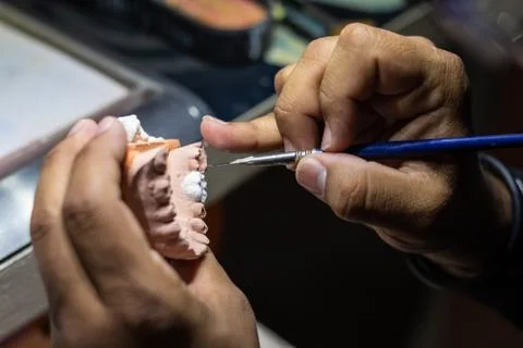 Close up of a man working with a prosthetic tooth Stock Photos
