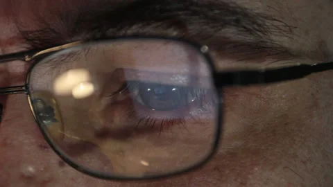 Close-up, man works in front of pc with screen reflecting on glasses lens Stock Footage 130864408