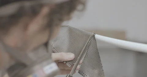 Close up of man in workshop carefully cutting fiberglass on surfboard surface Stock Footage 159820409