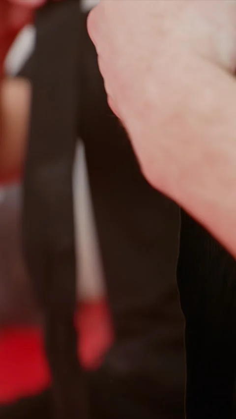 Close up man wrapping black hand wraps around wrists and fingers in indoor red Stock Footage 345547597
