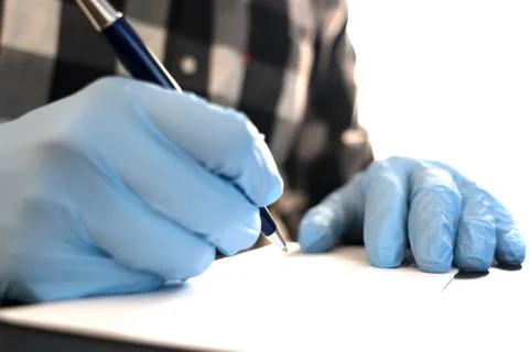 Close up of man writing on an envelope while wearing gloves during COVID-19 Stock Photos