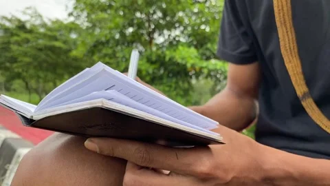 Close up of Man Writing in Notebook Outdoors Stock Footage 321136041