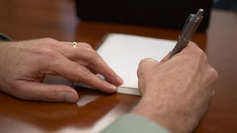 Close-up of a man writing notes on paper in a meeting. Stock Footage 99999716
