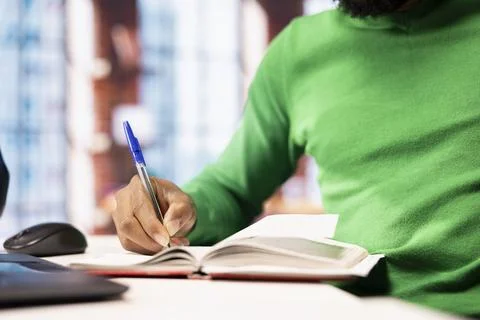 Close up of man writing personal notes in apartment workspace Stock Photos