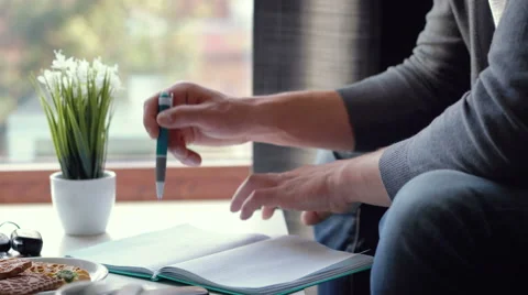 Close up of a man writing something in a notebook Stock Footage 65376219