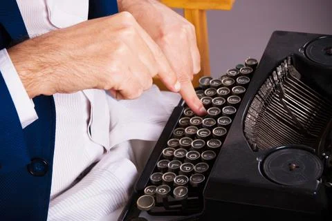 Close-up of man writing on typewriter. Stock Photos