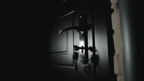 Close-up of a man&amp;#039;s hand opening the front door to a house with a key 動画素材 334941762