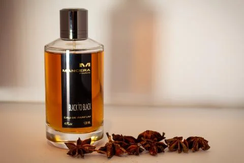 Close up of Mancera Back to Black eau de parfum and spices against a plane wh Stock Photos